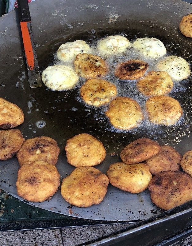 Aloo tikki / Aloo tikki chaat的图片，在一个大平底锅上用热油油炸，印度街头小吃小贩，印度街头小吃摊，不健康的饮食，新德里，印度，德里肚子